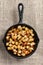 High angle shot of Fried Breakfast Potatoes in a cast iron skillet. Peppers, onions and potato cubes fill the skillet on burlap