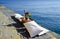 High angle shot of a fruit bowl and a bottle of champaign on the pier by the calm ocean