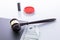 High angle shot of a gavel and some dollar bills on a white surface