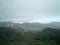 High angle shot of houses in the middle of a mountainous scenery partially covered in fog in Hawaii