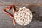 High angle shot of a large mug of hot cocoa with marshmallows and two candy canes forming a heart on a rustic wood table