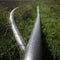 High angle shot of long pipes in the grass - perfect for a background