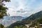 High angle shot of mountain cut for road near terrace type crop fields and cloudy sky in the background