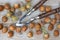 High angle shot of a nutcracker among hazelnuts scattered on a wooden surface