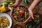 High angle shot of a person holding a plate of Ethiopian food with vegetables on a wooden table