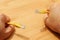 High angle shot of a person holding yellow cables with both hands over a wooden surface