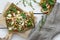 High angle shot of pieces of Sicilian pizza with different kinds of vegetables on a white surface