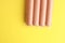 High angle shot of sausages in plastic packaging on a yellow background