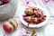 High angle shot of a small bowl of edible rose flowers and a vegan peach cookie on a table