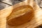 A high angle shot of sourdough bread on a light wooden cutting board on a darker wood surface