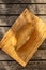 A high angle shot of sourdough bread on a light wooden cutting board on a darker wood surface