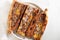 High angle shot of three pieces of homemade pizza on a white plate on white surface