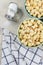 High angle shot of two different colored bowls of fresh popped popcorn with towl and salt shaker with salt spilling out. Vertical