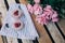 High angle shot of two portions of strawberry yogurt and peonies on the bench- romantic date