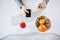 High angle shot of woman having lunch in front of computer, holding rolled cake and smartphone. Busy woman eat while