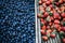 High angle shot of wooden boxes of delicious strawberries and blueberries