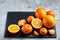 High angle still life view of sliced ruby orange and tangerine arranged together on stony board