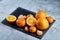 High angle still life view of sliced ruby orange and tangerine arranged together on stony board