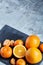 High angle still life view of sliced ruby orange and tangerine arranged together on stony board