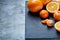 High angle still life view of sliced ruby orange and tangerine arranged together on stony board