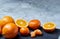 High angle still life view of sliced ruby orange and tangerine arranged together on stony board