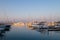 High-angle of sunlit Antibes port at sunrise ships around purple clear sky background