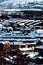 High-angle vertical of a snowy sunlit town mountains background