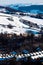 High-angle vertical of a snowy sunlit town mountains background