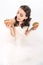 high angle view of attractive young bride in wedding dress holding burgers in hands