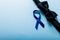 High angle view of blue prostate cancer awareness ribbon with black bowtie on blue background