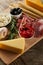 High angle view of board with breadsticks, cheese and antipasto ingredients