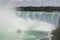 High-angle view of the boat with tourists in red raincoats sailing against Niagara Falls