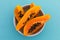 High angle view of bowl of freshly cut papaya on blue background