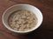 High angle view of a bowl of peanut soup isolated on wooden background.