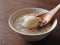 High angle view of a bowl of peanut soup isolated on wooden background. Wooden spoon scooping up dumpling.