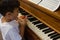 High angle view of boy eating apple while sitting by piano