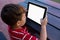 High angle view of boy using digital tablet while sitting at table