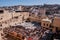 High-angle view of the cityscape and traditional tannery vats on a sunny day in Fes