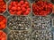 High angle view on different fresh ripe berries in plastic bowls on german farmer market