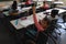 High angle view of disable schoolgirl looking at camera and raising hand in classroom