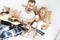 High angle view of father and cute little daughter with teddy bear looking at acoustic guitar