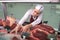 High angle view female butcher picking meat in butchery