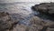 High angle view of foamy stormy sea waves rolling splashing on rocks at sunset. Picturesque scenery of Mediterranean