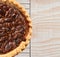 High angle view of a fresh baked holiday Pecan Pie on a cooling rack atop a rustic wood kitchen table