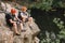 high angle view of friends cyclists with backpacks resting with sport bottle of water on rocky cliff near river