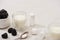 High angle view of glasses of yogurt, teaspoon, containers with starter cultures near sugar bowl with blackberries