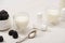 High angle view of glasses of yogurt, teaspoon, containers with starter cultures and sugar bowl with blackberries