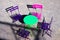 High angle view on green round table with four wood pink and purple folding chairs outdoor in bright sunlight