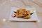 High angle view of isolated traditional dim sum pan fried turnip or carrot cake beautifully plated with leaf and flower petals in