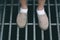 High Angle View of Lower Section of A Boy Standing on Steel Grating